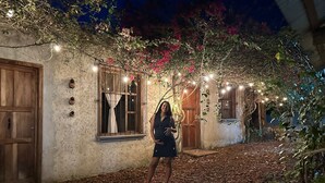 A rustic building with a cobblestone courtyard, wooden doors, and string lights. - Yaxlik River lodge (San Agustin Lanquin)