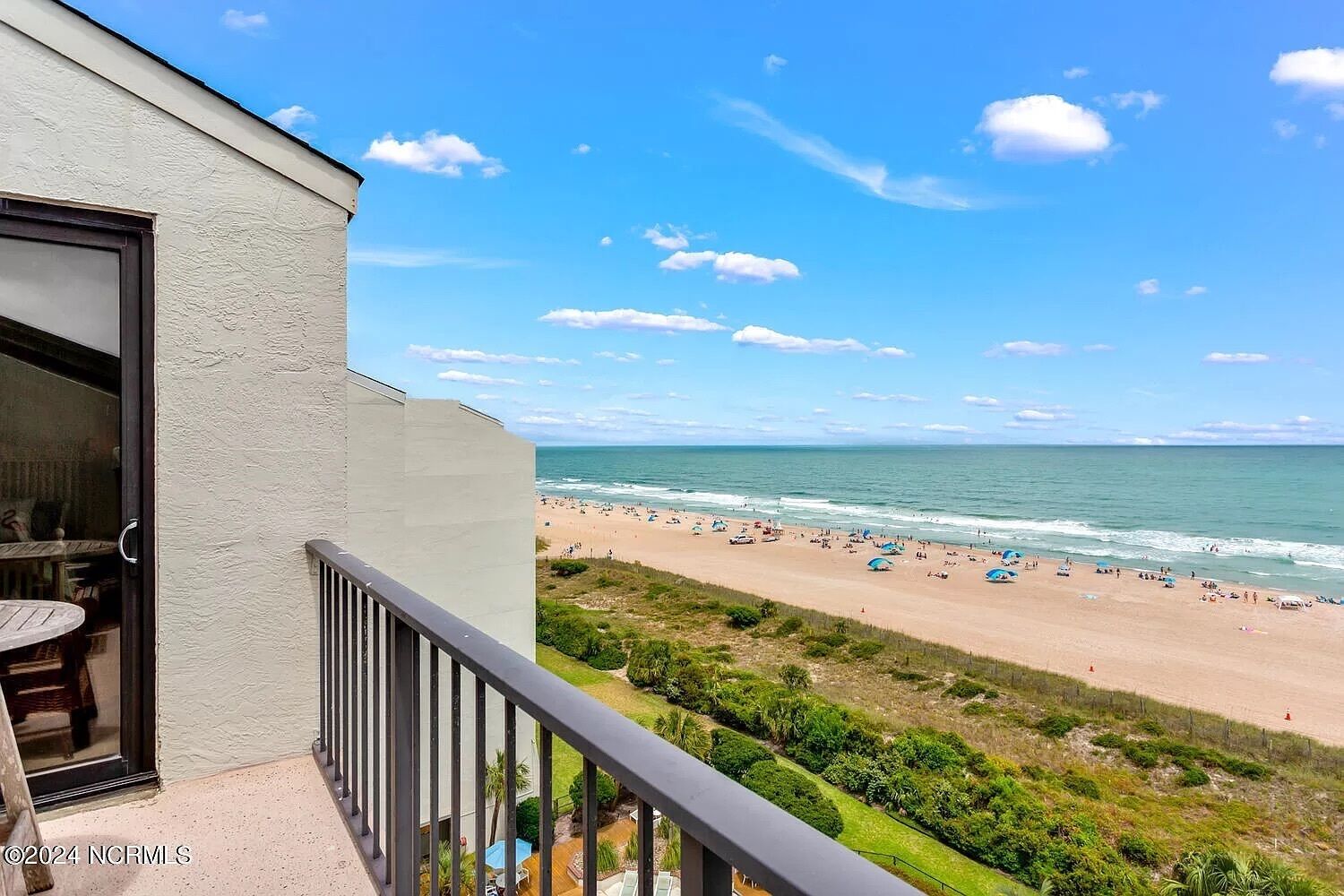 Ein Balkon mit Blick auf Strand und Meer.