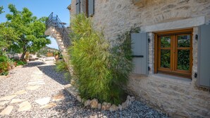 Un bâtiment en pierre avec une fenêtre en bois et un escalier menant à un balcon.