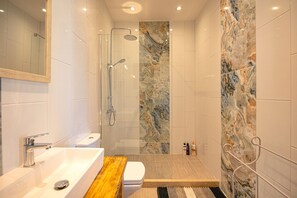 A modern bathroom with a glass-enclosed shower, a wooden vanity, and a marble accent wall. - Charming Villa in Agnitsini, Corfu – Pool, WiFi, Aircon (Agnitsini)