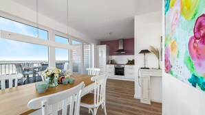 A modern kitchen with white cabinets and a large window overlooking a balcony. - Stunning apartment in Olpenitz (Olpenitz)