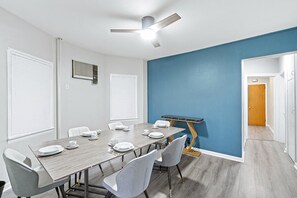 A conference room with a long table, chairs, and a ceiling fan.