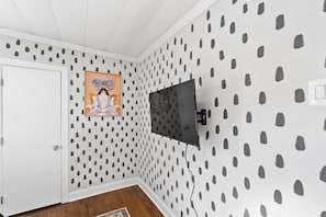 Cozy retreat with a flat-screen TV and artwork above the door, set against a unique polka dot wall.