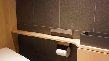 Ein kleines Badezimmer mit Toilette, Ablagefläche und Papierhandtuchspender.