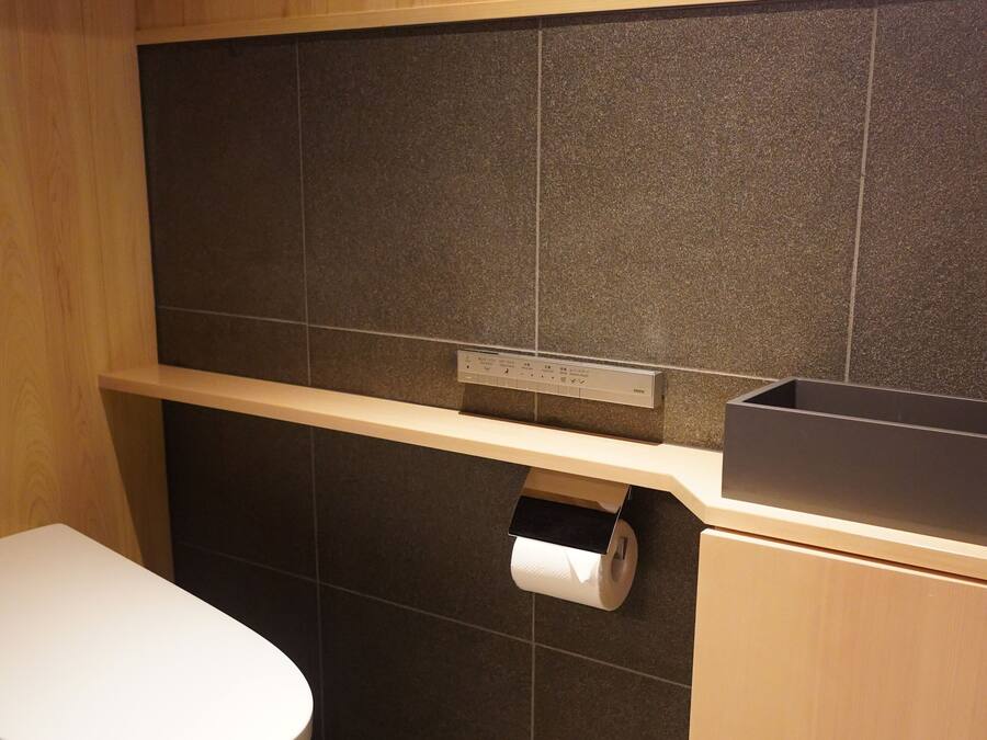 Ein kleines Badezimmer mit Toilette, Ablagefläche und Papierhandtuchspender.
