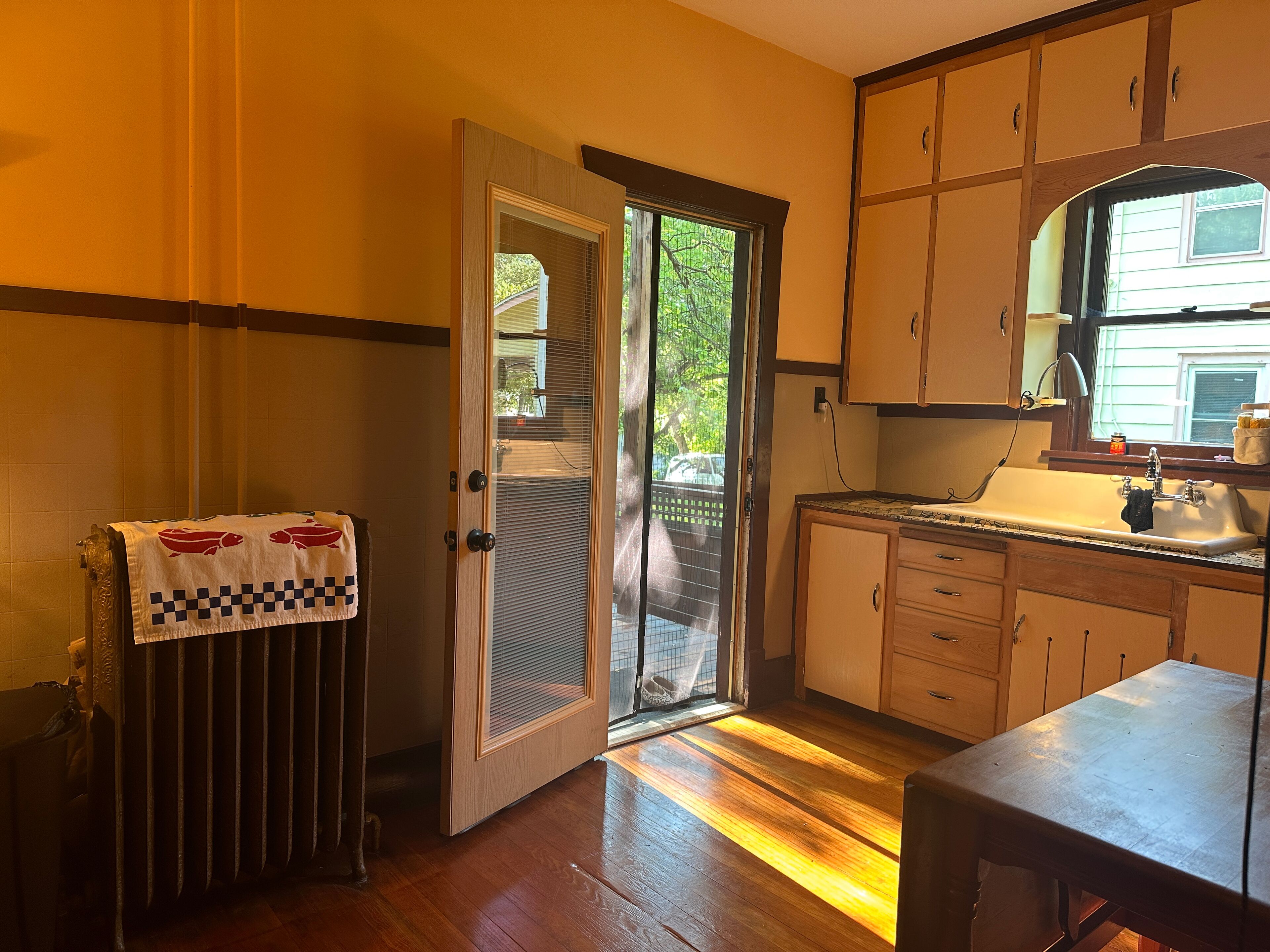 A kitchen with wooden cabinets, a sink, and a window.