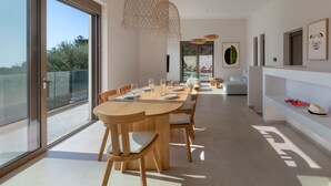 A modern dining area with a large table, chairs, and pendant lights. - Villa Eptanisa in Sivota (Lefkada)