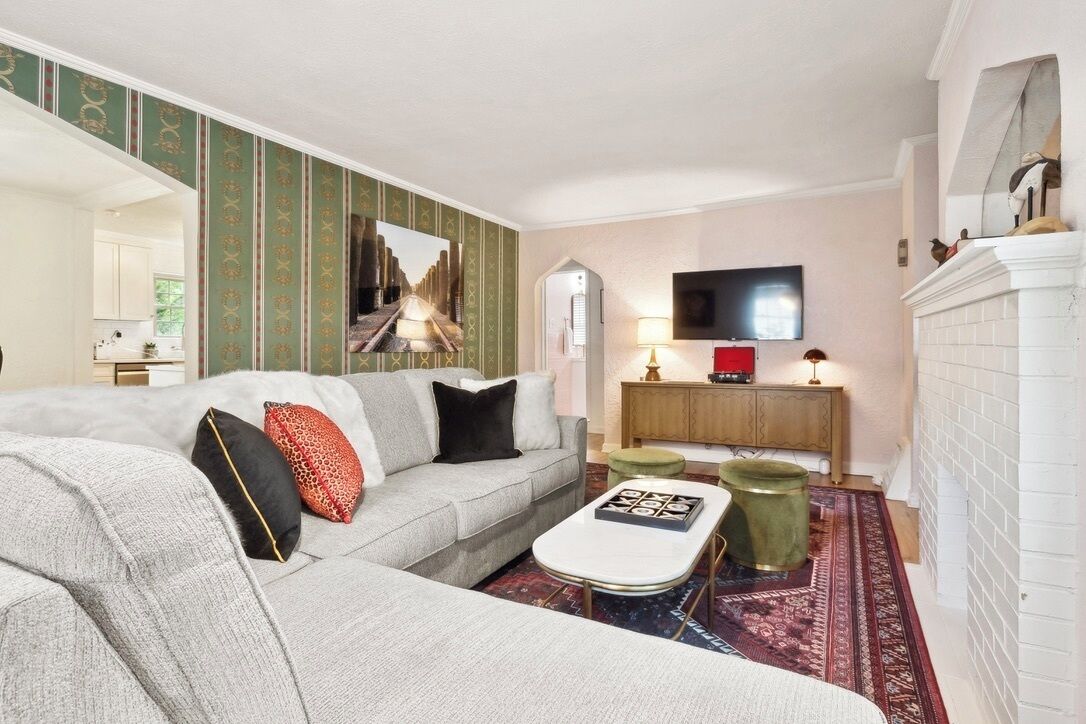 Un salon moderne avec un canapé gris, une table basse, un téléviseur et une cheminée.