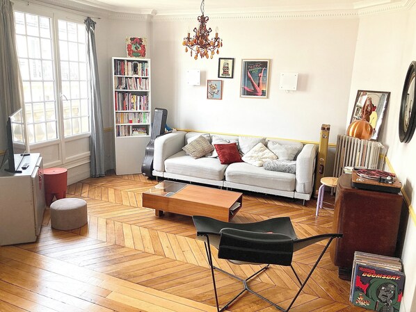 Relax in this inviting living space with a sofa, coffee table, and bookshelf.