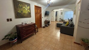 Een ruime woonkamer met een groot schilderij, een houten kast en een bank.
