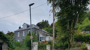 A residential street with a speed limit sign, houses, and lush greenery. - Little Bay View in Oban (Oban)