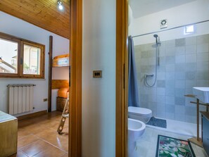 Bathroom features a shower area with a toilet and sink, plus a radiator and window.