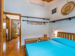 Cozy retreat with a single bed, wooden bench, and woven basket.