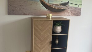 A wooden herringbone-patterned cabinet with a pineapple ornament and a small potted plant on top. - Welcome to our serenity in the Gold Coast which is "Bee Cottage".
 (Robina)