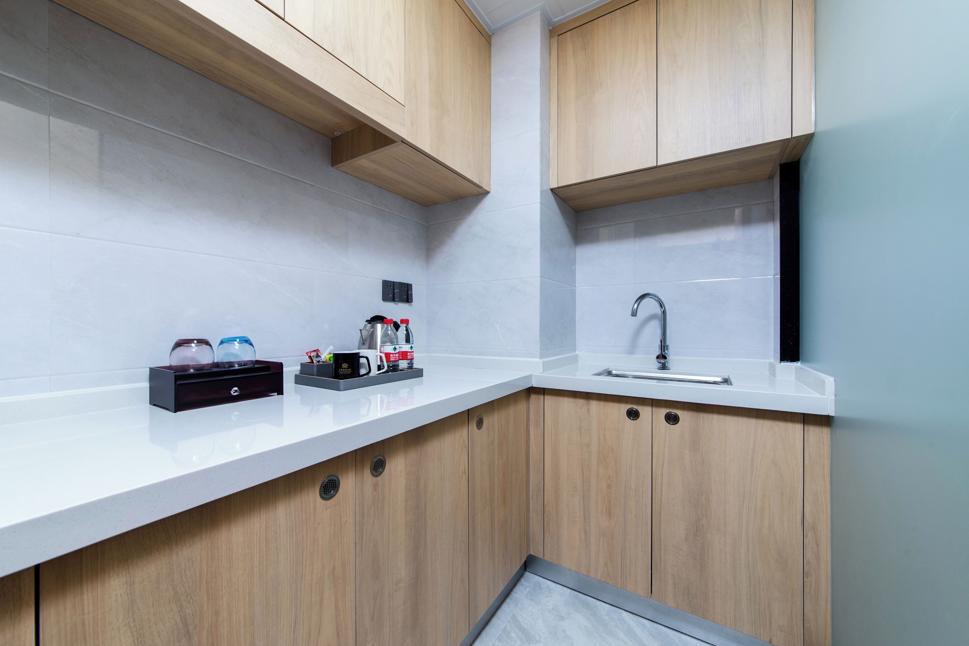 Una cocina moderna con armarios de madera, encimera blanca y un lavabo.
