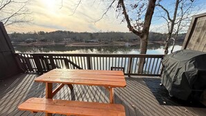 Une terrasse en bois avec une table de pique-nique et un barbecue.