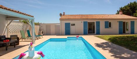 Una piscina rectangular con un muelle de madera en primer plano.