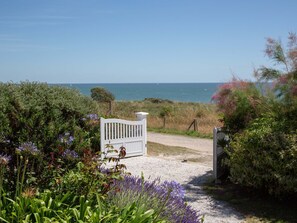 A pathway leading to a white gate with a view of the sea. - Le Bigorneau Préfaillais by Interhome (La Plaine-sur-Mer)