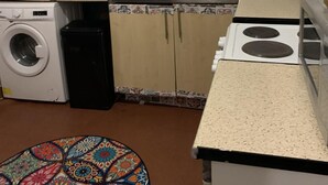 A compact kitchen with a washing machine, a sink, and a stove. - Sleeps 2 with Free Parking and Wi-Fi (Birmingham)