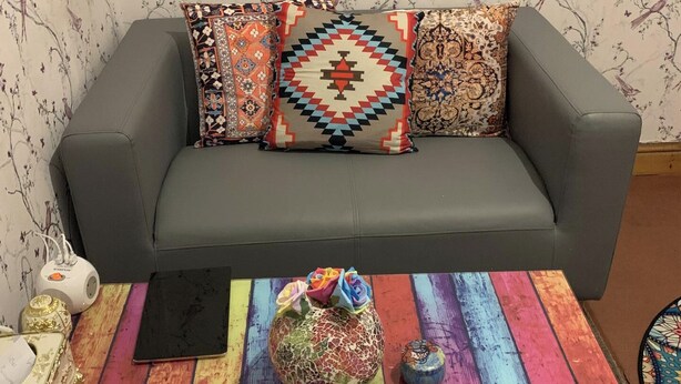 A grey sofa with patterned cushions, a colorful wooden coffee table with a decorative vase, and a small white speaker. - Sleeps 2 with Free Parking and Wi-Fi (Birmingham)