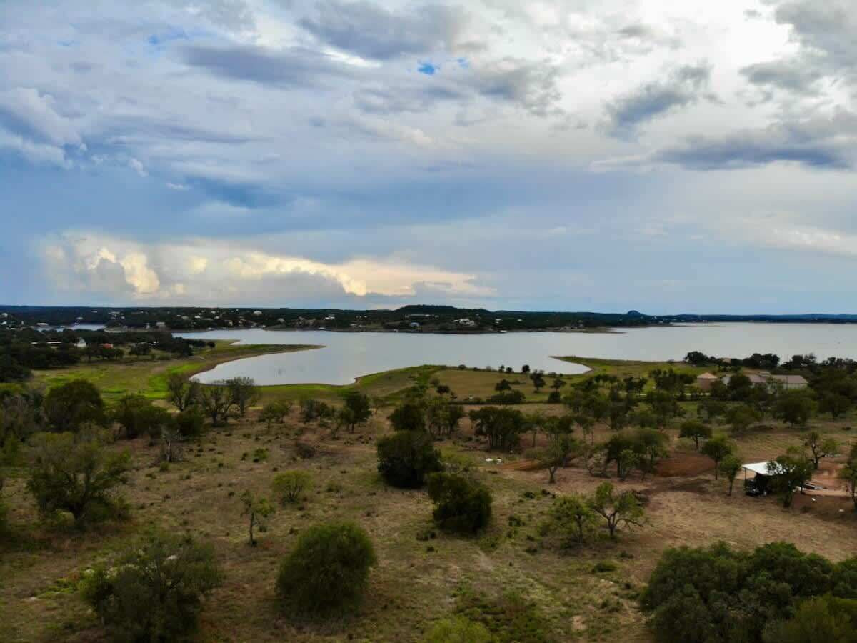 Vista al lago con un edificio pequeño y árboles.