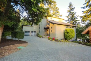 A modern two-story house with a garage, surrounded by well-maintained landscaping and tall trees. - Starlake Villa Waterfront (Kent)