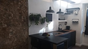 A modern kitchen with a central island, pendant lights, and a built-in oven.