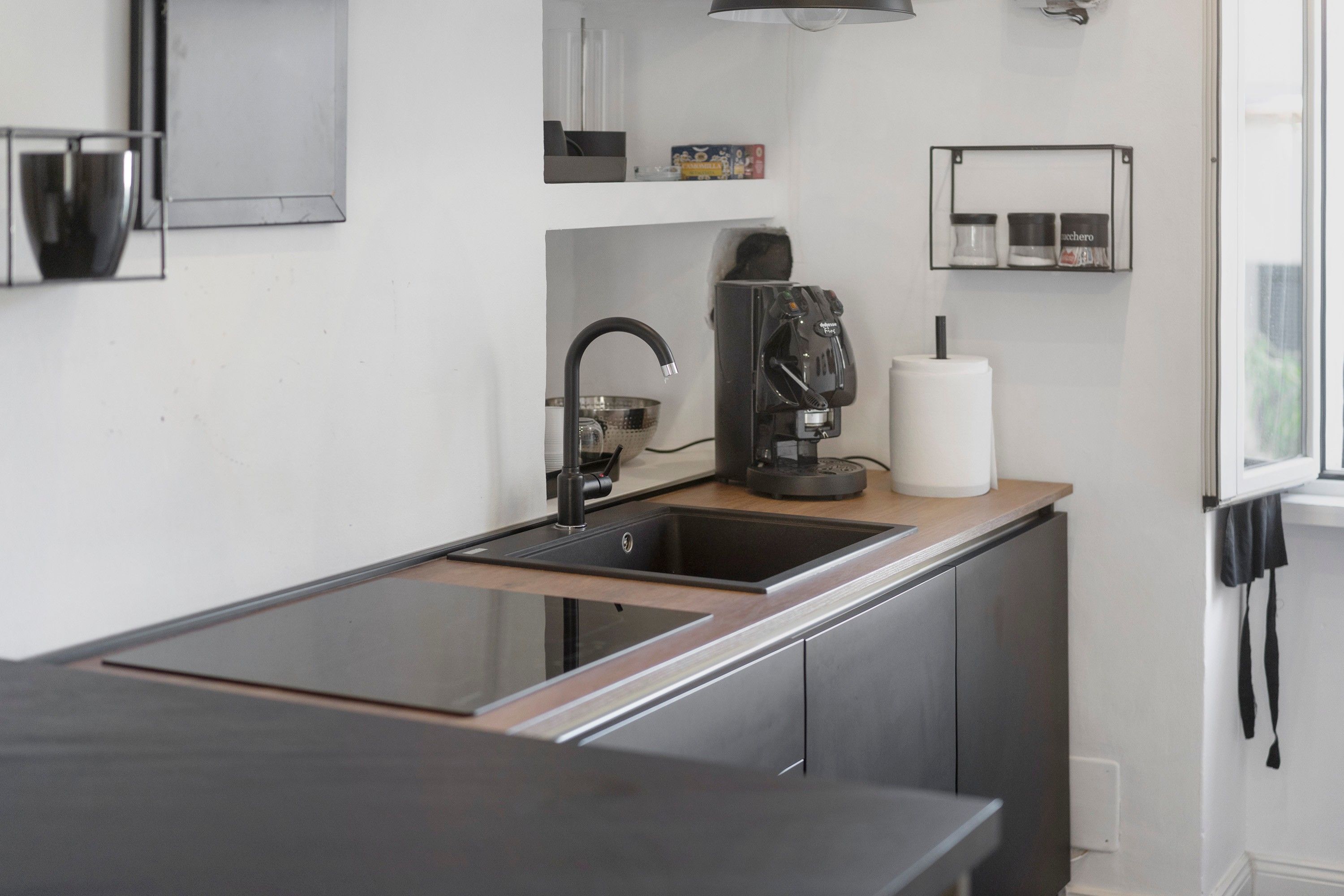 Eine moderne Küche mit schwarzem Arbeitsplatz, Edelstahlgeräten und einer eingebauten Spüle.