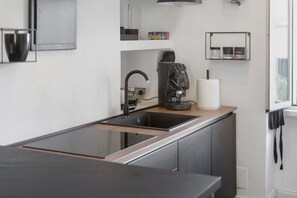A modern kitchen with a black countertop, stainless steel appliances, and a built-in sink. - Apartment 'Appartamento Luxury - Torre' with Air Conditioning (Terracina)