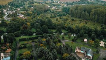 Vista aerea di una zona residenziale con case, aree verdi e un fiume.
