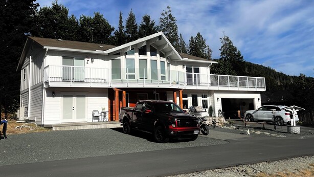 A two-story house with a garage, a covered driveway, and a black SUV parked in front. - Quiet corner on Burman (Gold River)