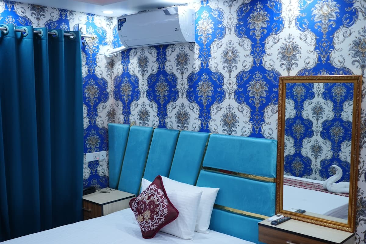A hotel room with a bed, a nightstand, a mirror, and a ceiling fan.
