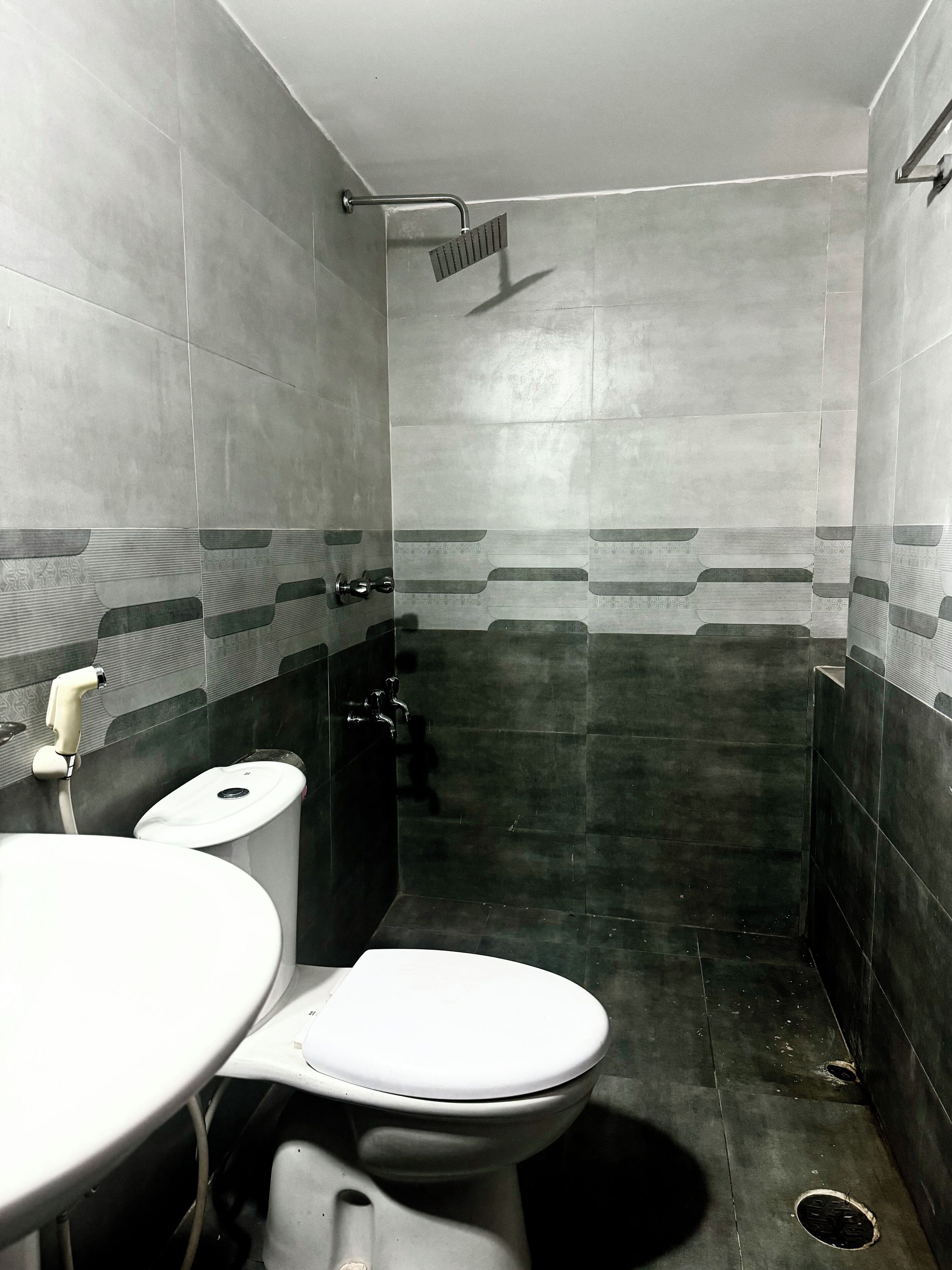 A small, compact bathroom with a toilet, sink, and shower.