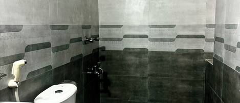 A small, compact bathroom with a toilet, sink, and shower.