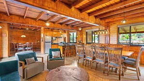 Una cabaña de madera espaciosa con comedor, cocina y sala de estar.