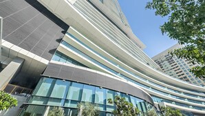 A modern building with a curved facade, large windows, and a prominent tower. - Dubai Marina 3BR in Vida | Pool, Gym, Balcony, Walk Everywhere (Dubai)