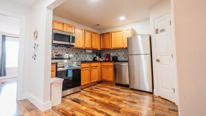 A kitchen with wooden cabinets, stainless steel appliances, and a patterned backsplash.