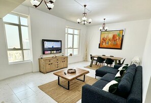 Relax in this stylish living room with a large flat-screen TV, comfortable sofa, and dining area.