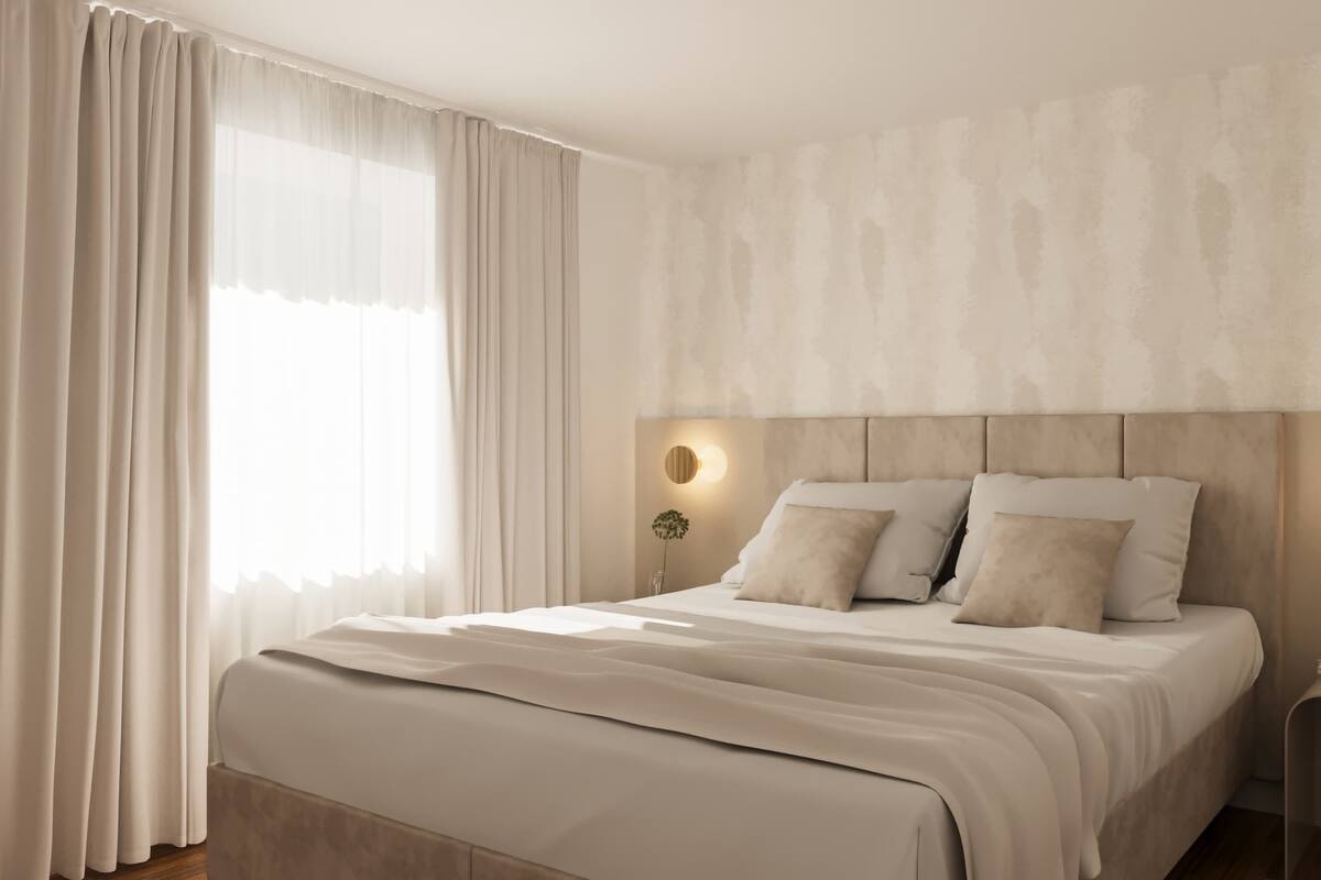 A modern bedroom with a large bed, a nightstand, and a wall-mounted light fixture.