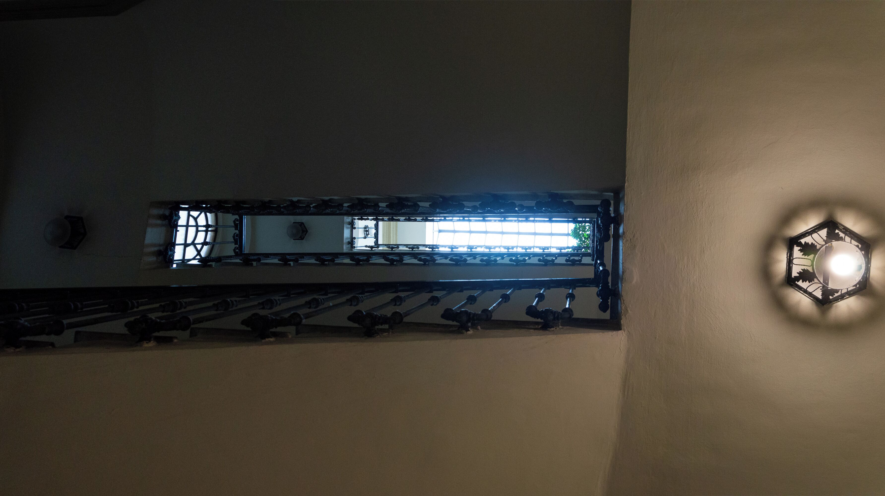 A staircase with a handrail and a wall-mounted light fixture.