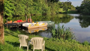 A lakeside setting with a dock, boats, and chairs. - Mobile home near the Puy du Fou ! (Maulevrier)