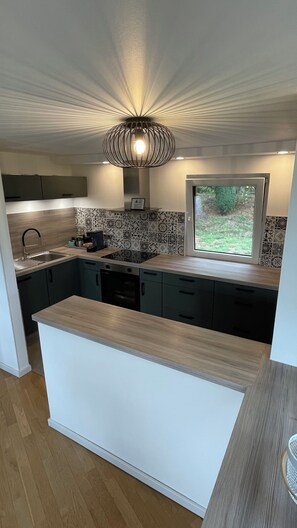 A modern kitchen with a central island, built-in appliances, and a view to the outdoors.