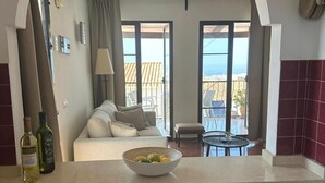 Une cuisine avec un coin repas, un canapé et une vue sur la mer.