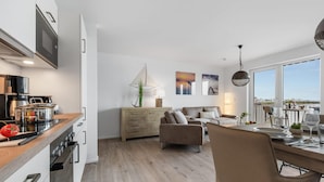Une cuisine moderne avec un coin repas, un canapé et une vue sur la ville.