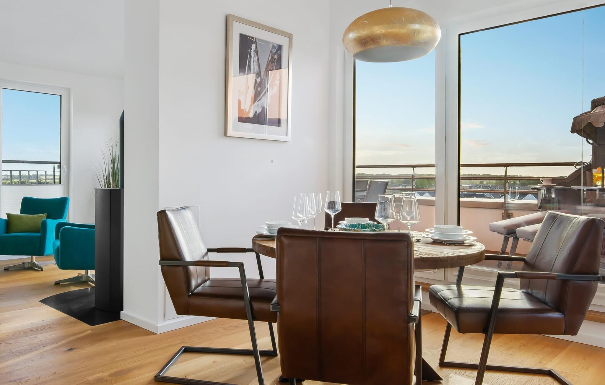 A modern living room with a dining area, large windows, and a view of the cityscape.
