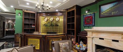 A lobby with a reception desk, seating area, and a fireplace.