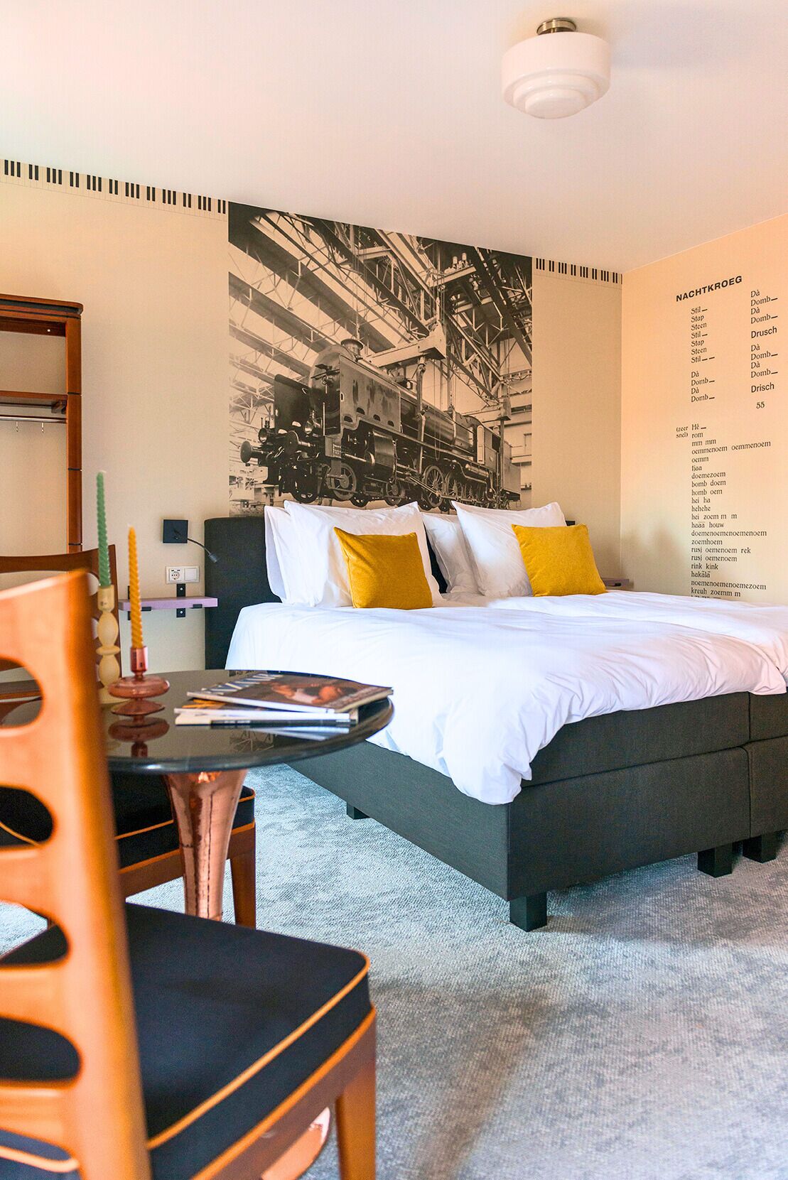 A modern hotel room with a large bed, a small table, and a chair.