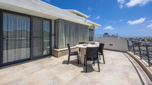 A modern outdoor terrace with a round table and chairs, large windows, and a view of the city. - For those who prefer to cook their own meals, this kitchen is well-equipped and is a beautiful space to create heartly dishes!! <br>Towels and linen are included, Kettle, Toaster, Hair dryer, Washing machine, coffee maker, dishwasher, microwave. (Il-Mellieħa)