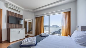 A hotel room with a bed, a flat-screen TV, a wardrobe, a desk, and a balcony with a view of the city. - For those who prefer to cook their own meals, this kitchen is well-equipped and is a beautiful space to create heartly dishes!! <br>Towels and linen are included, Kettle, Toaster, Hair dryer, Washing machine, coffee maker, dishwasher, microwave. (Il-Mellieħa)