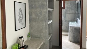 A modern kitchen with a built-in island, a framed artwork on the wall, and a view into the adjacent bathroom. - Mealanies House (Unawatuna)